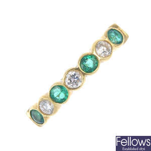 An 18ct gold diamond and emerald half-circle eternity ring.
