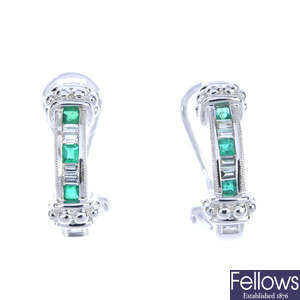 A pair of emerald and diamond half hoop earrings.