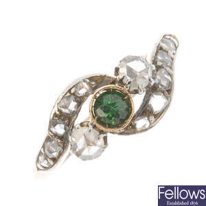 A green gem and diamond crossover ring.