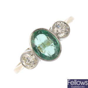 An emerald and diamond three-stone ring. 