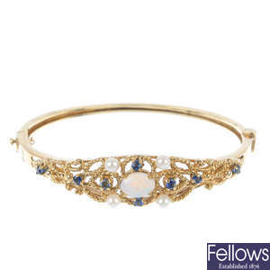 A 9ct gold opal, sapphire and cultured pearl, openwork hinged bangle.