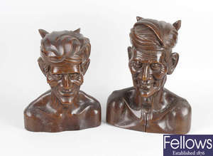 A pair of Eastern carved wooden busts plus another, and a wall plaque.
