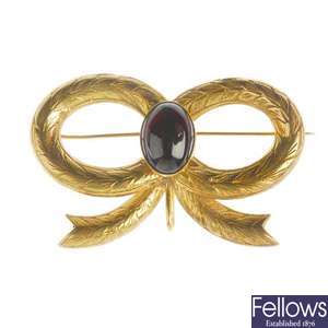 A late 1960s 9ct gold garnet bow brooch.