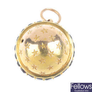 A late Victorian gold garnet stanhope charm.