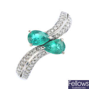 An emerald and diamond crossover ring.
