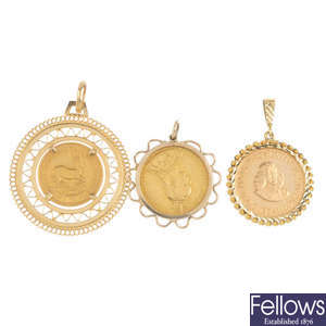 Three mounted coin pendants.