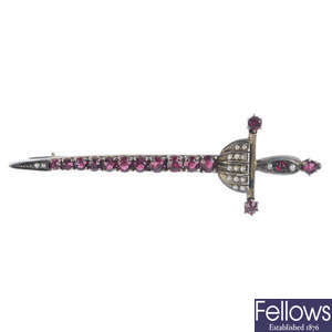 An early 20th century continental white metal, garnet and split pearl sword brooch.