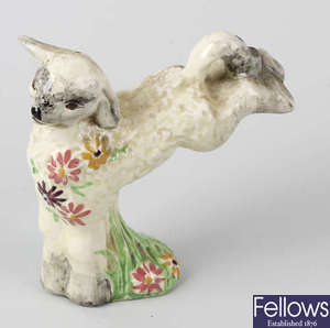 A Clarice Cliff figurine, modelled as a Spring lamb with floral garland.