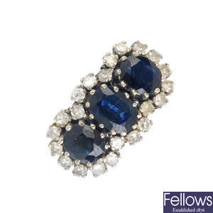 A sapphire three-stone and diamond cluster ring.