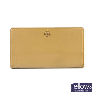 CHANEL - a beige bi-fold wallet.