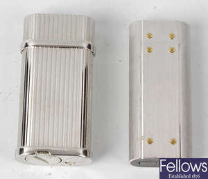 Two Cartier white metal lighters.
