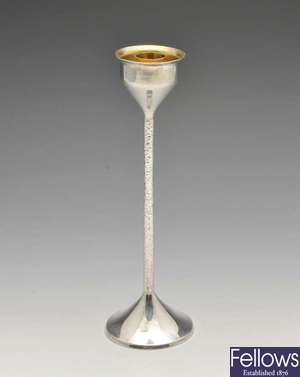 A single silver candlestick of modern design.