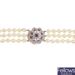 A cultured pearl three-row necklace, with 18ct gold ruby and diamond clasp.