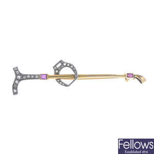 An early 20th century gold diamond and ruby riding crop brooch.