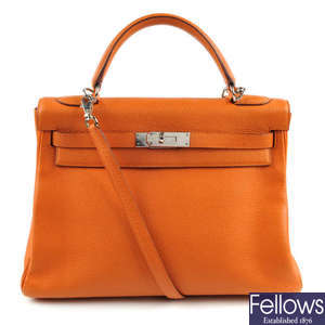 HERMES - an orange Togo Kelly 32 handbag.