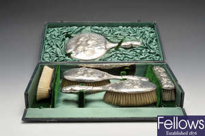 A cased Edwardian silver mounted six piece dressing table set.