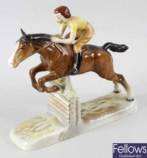 A Beswick figure modelled as a bay horse and female rider mid jump.