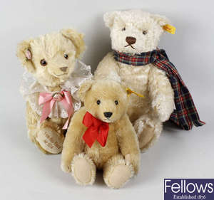 Two boxes containing a good mixed selection of assorted modern teddy bears, together with two violins and bows in fitted cases.