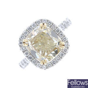 A Fancy Yellow diamond and diamond cluster ring.