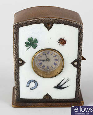 A hide cased desk clock with enamelled face.