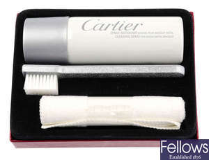 CARTIER - a cleaning set for a bracelet watch, to include cleaning spray, a brush and a cleaning cloth.