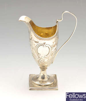 A George III silver helmet cream jug & an Indian Colonial silver pepper pot.