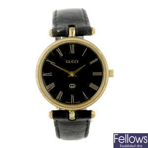 GUCCI - a lady's gold plated wrist watch together with a lady's gold plated Gucci bracelet watch.