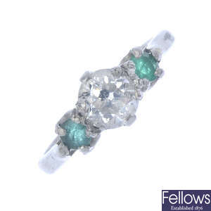 A platinum diamond and emerald three-stone ring.