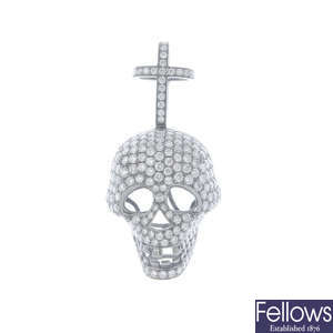 A diamond cross and skull pendant.