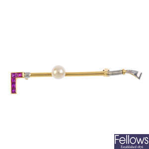 A cultured pearl and ruby riding crop brooch.