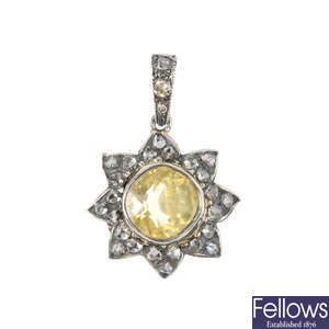 A sapphire and diamond sun pendant.