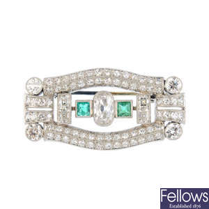 An Art Deco platinum diamond and emerald brooch.