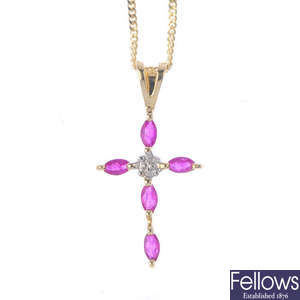 A ruby and diamond cross pendant.
