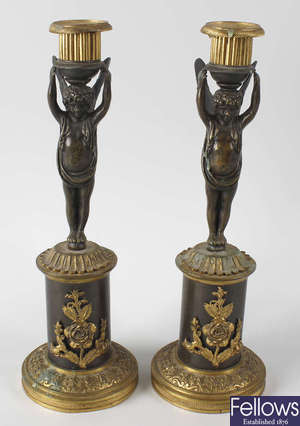 A pair of early 19th century French bronze figural candlesticks