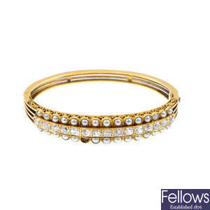 A late Victorian gold, diamond and split pearl hinged bangle.