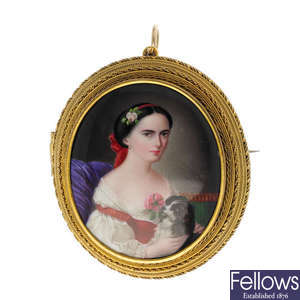 A mid Victorian gold enamel portrait female and lap dog brooch.